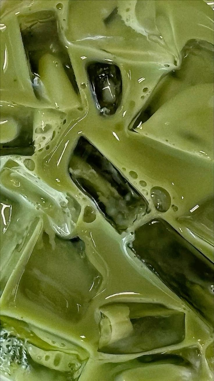 Macro shot of iced matcha latte with ice cubes