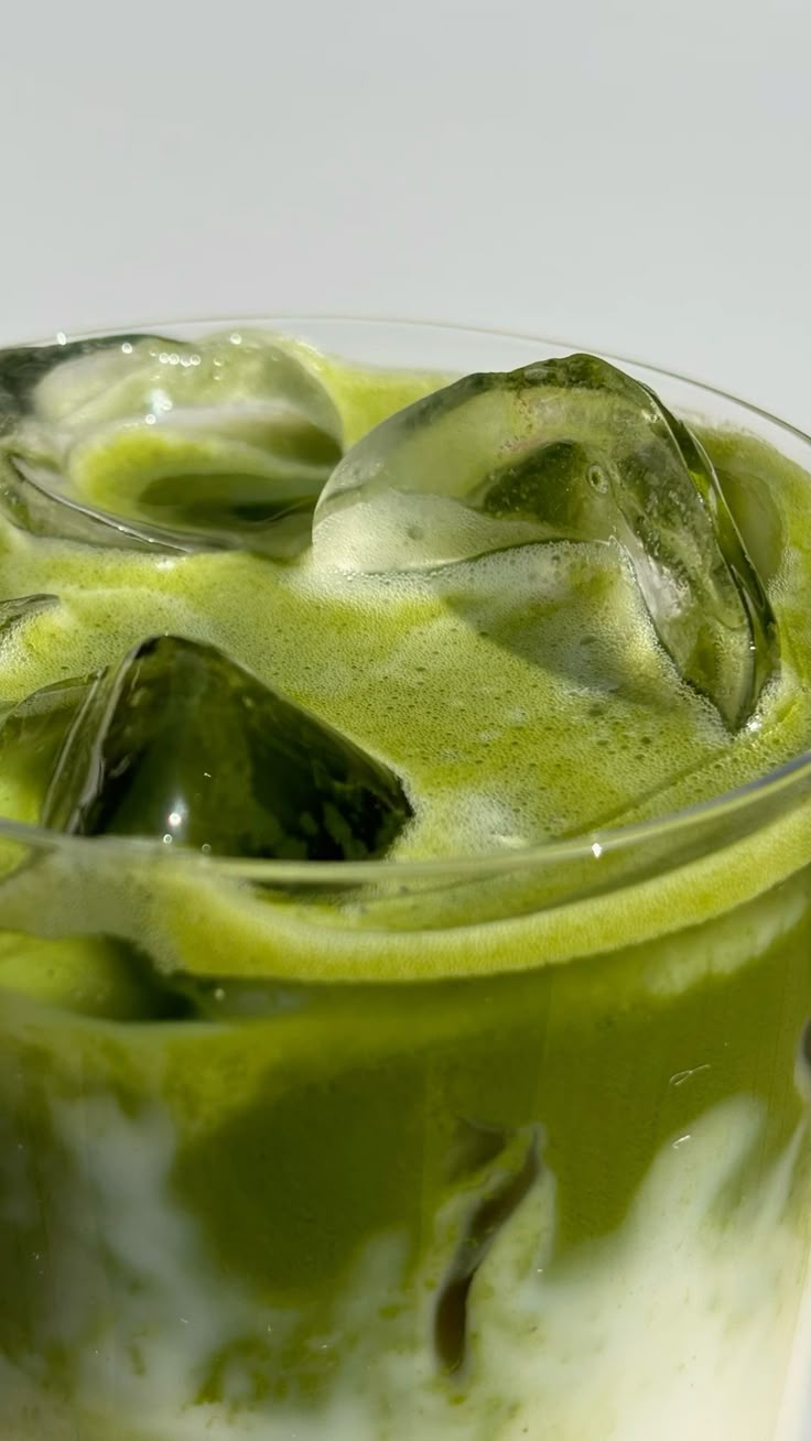 Close-up of an iced matcha latte with ice cubes in a glass